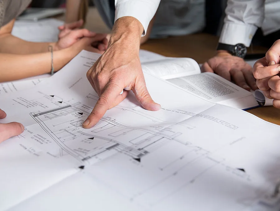 Plans de chantier symbolisant les garanties et la préparation